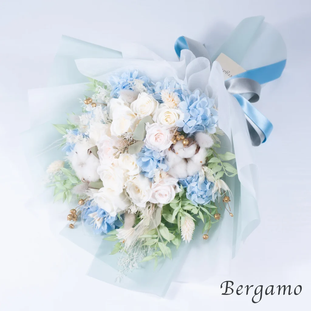 白と淡いブルーの花材を束ねたブーケ、フロストの俯瞰アングルの画像