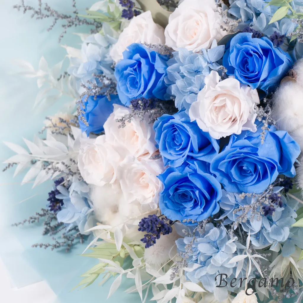 ブルーと淡いピンクのプリザーブドローズを近くで見せた、Bergamoのローズブーケ「azure」の花材アップ