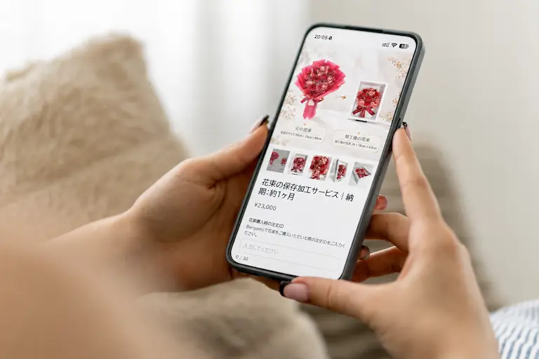 スマートフォンでBergamoの花束保存加工サービスの注文画面を確認している様子